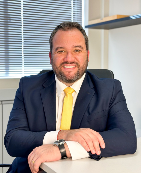 Foto de um advogado sorrindo e usando terno, representando a Munhoz Fernandes Advogado, na seção inicial da landing page.